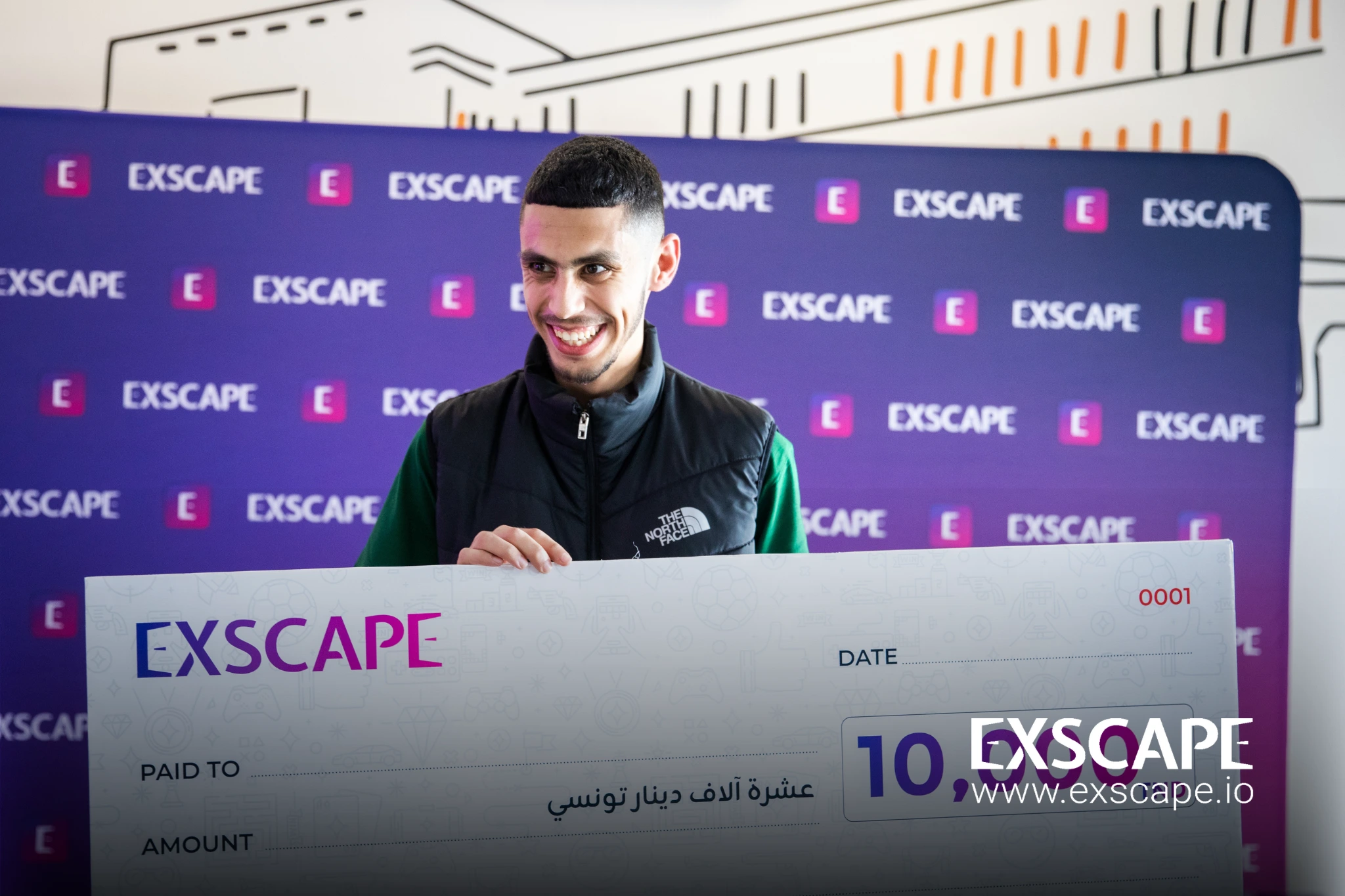 winner of the exscape games competition holds his check up proudly