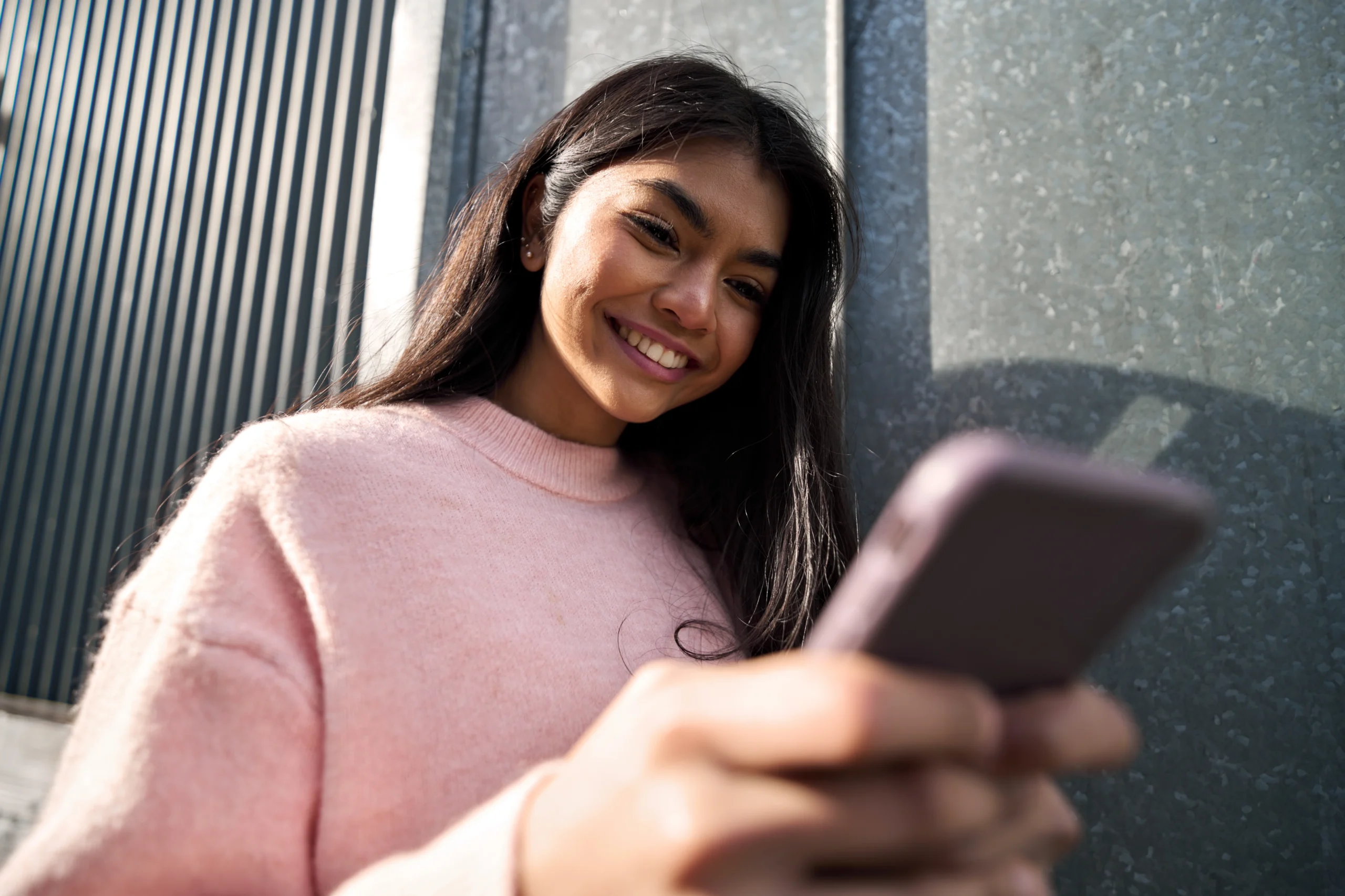 Young woman plays happily on her phone. playing games online and winning prizes and money